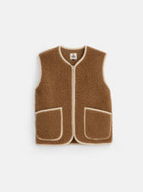 The Coldbreaker Standard Vest is a brown, sleeveless fleece vest featuring two front pockets and beige trim along the edges. Made from cozy Irish wool, it is displayed on a plain white background and offered in unisex sizing.