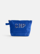 The Painted Perfect Canvas Pouch is a small blue zippered pouch with a side handle and white "SMP" letters on the front, shown against a plain white background.
