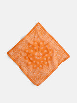 Bandana in Cotton Voile featuring an orange color with a white paisley pattern, crafted from soft cotton voile and displayed flat on a white background. This vintage bandana is expertly made in Italy.