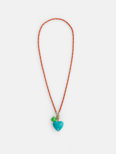 The Roxanne Assoulin Long Happy Cord Charm Necklace features a playful design with orange and white cording, a blue heart-shaped pendant, and a small green charm—both showcased against a white background. This cheerful accessory also comes with detachable charms for added versatility.