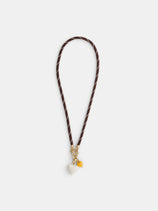 The Roxanne Assoulin Happy Cord Charm Necklace features a brown puffy heart with white stitching, gold hardware, and two detachable charms—a white heart and a yellow round bead—displayed against a plain white background.