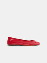 A side-profile view of the Prince Street Ballet Flat in red, featuring a small bow on the toe and a light brown flat sole, set against a plain white background.