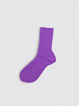 A single Maria La Rosa Bio Cotton Ribbed Sock in purple lies flat on a plain, light gray background. Evoking the refined quality of Italian artisan craftsmanship, this dress sock features ribbed detailing along the body with a smooth toe and heel area.